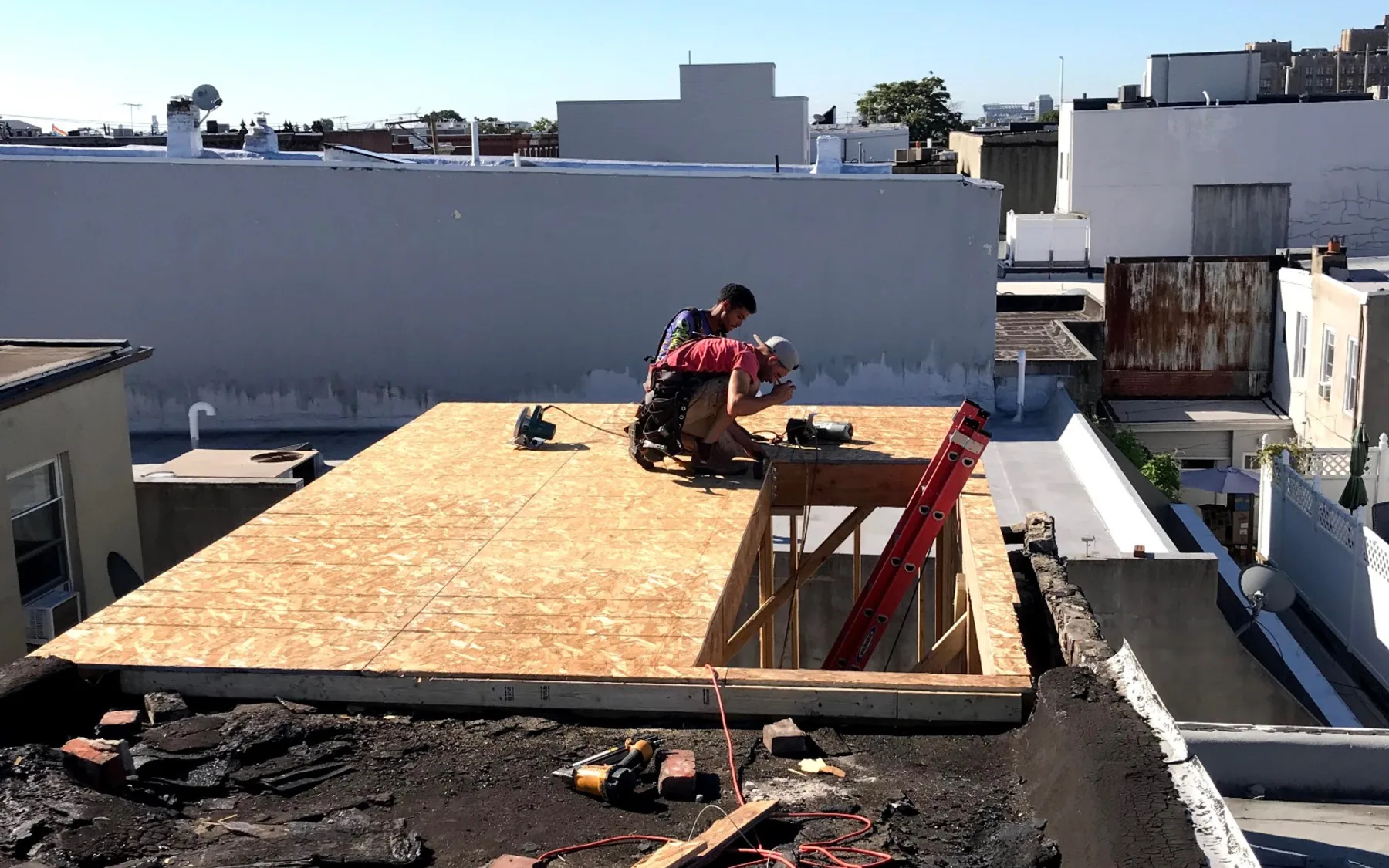Rooftop framing work on an urban residential property
